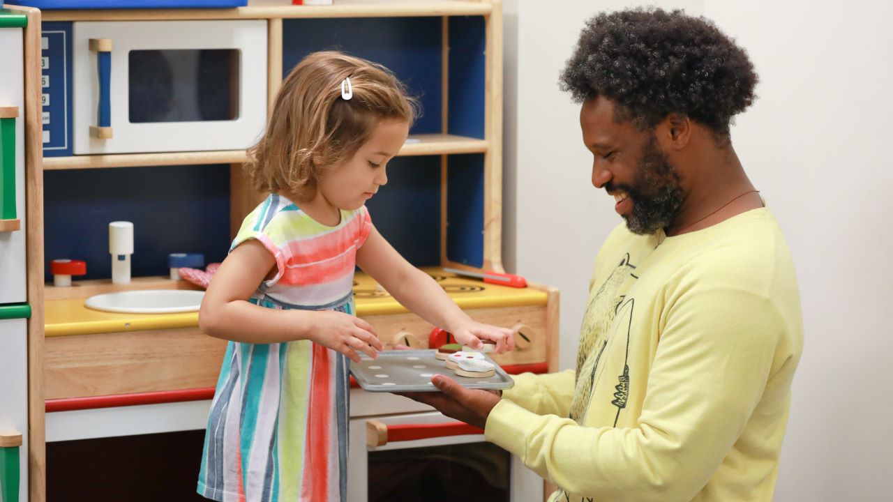 Man playing house with toddler